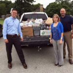 Officers of the Rotary Club of Clinton load up 1,643 pounds of food the club collected for their local food bank. Left to right are Kyle Adkins, president; Jesse Alldredge, vice president; and Parker Mills, secretary.