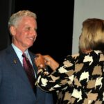 Susan Haralson pins the DG Nominee pin on Pau Reinert.