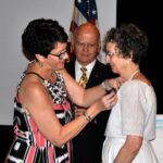 Julie Bixler pins the First Lady's tiarra on Mary Platt while Melvin looks on.